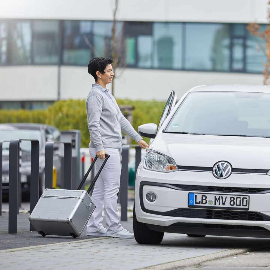 Eine &Auml;rztin des MVZ Team Buderer steigt mit Ihrem Koffer in das Auto, um Pflege- und Seniorenheime medizinisch zu betreuen.