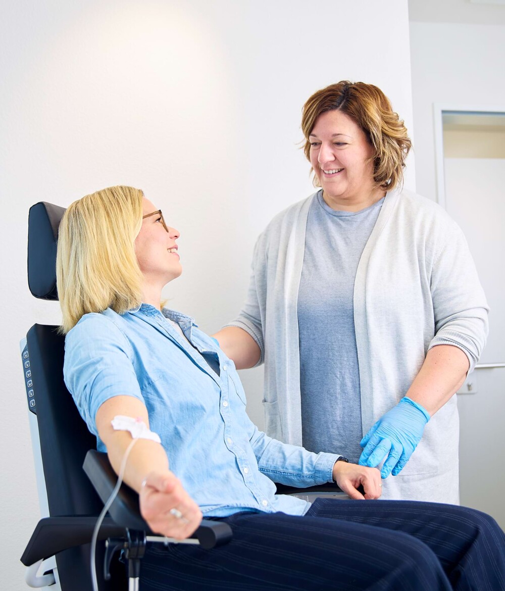 Eine junge Patientin auf einer Behandlungsliege, w&auml;hrend sie eine Medivitan Vitamin-Injektion erh&auml;lt.