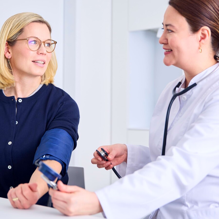 Eine &Auml;rztin nimmt eine Blutdruckmessung bei einer Patientin.