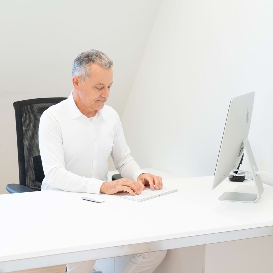 Ein Arzt arbeitet an einem modernen B&uuml;roplatz.