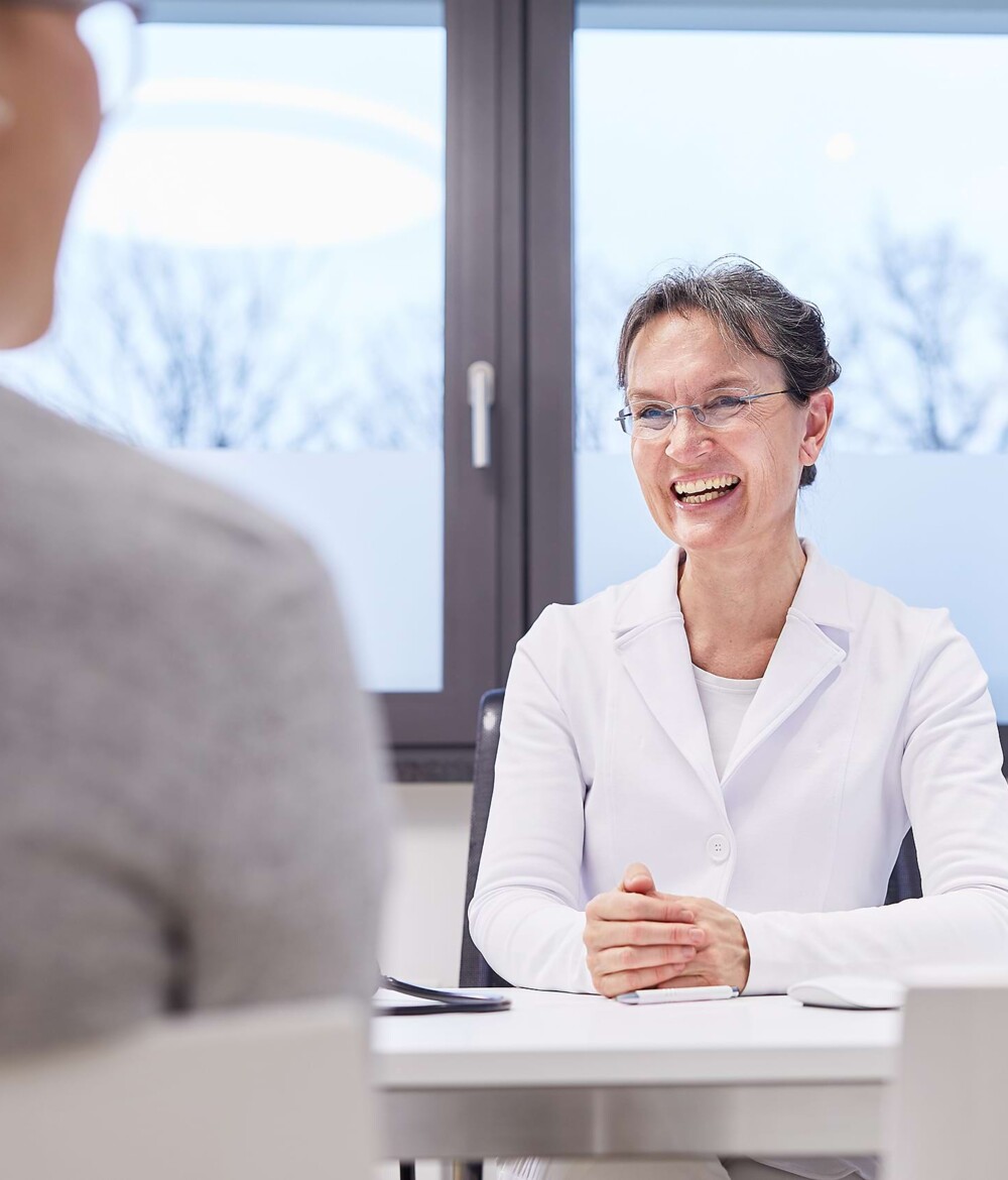 Eine &Auml;rztin ber&auml;t einen Patienten.