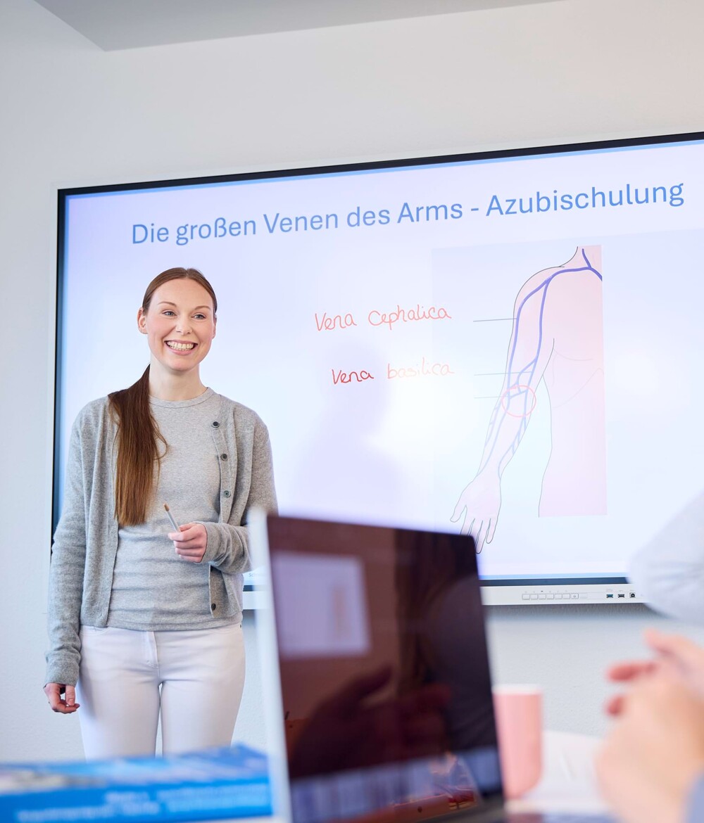 Eine Auszubildende h&auml;lt einen Vortrag zum Thema Venen w&auml;hrend einer Azubischulung.