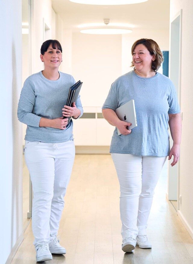 Zwei Mitarbeiterinnen laufen &uuml;ber den Flur.