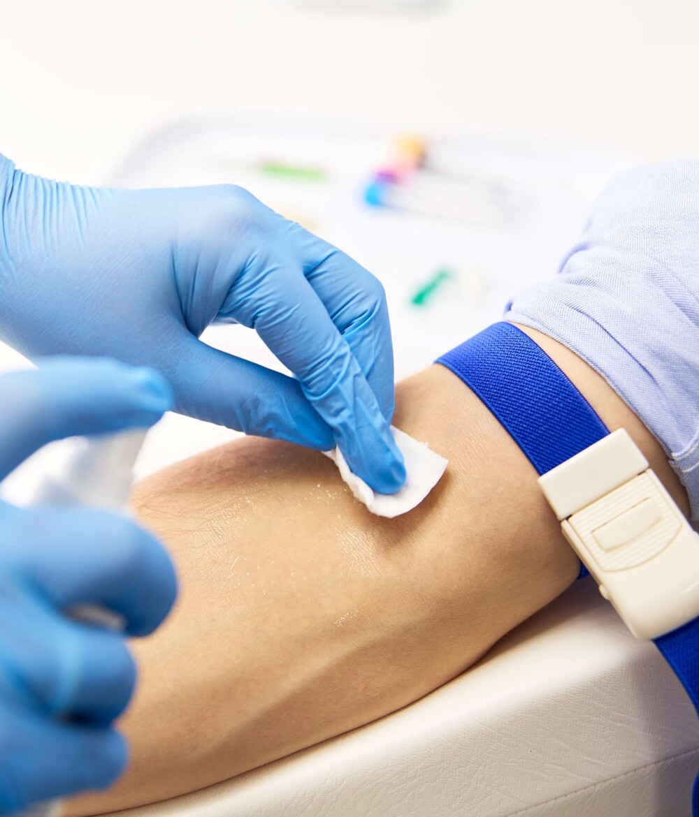 Der Arm eines Patienten wird desinfiziert.