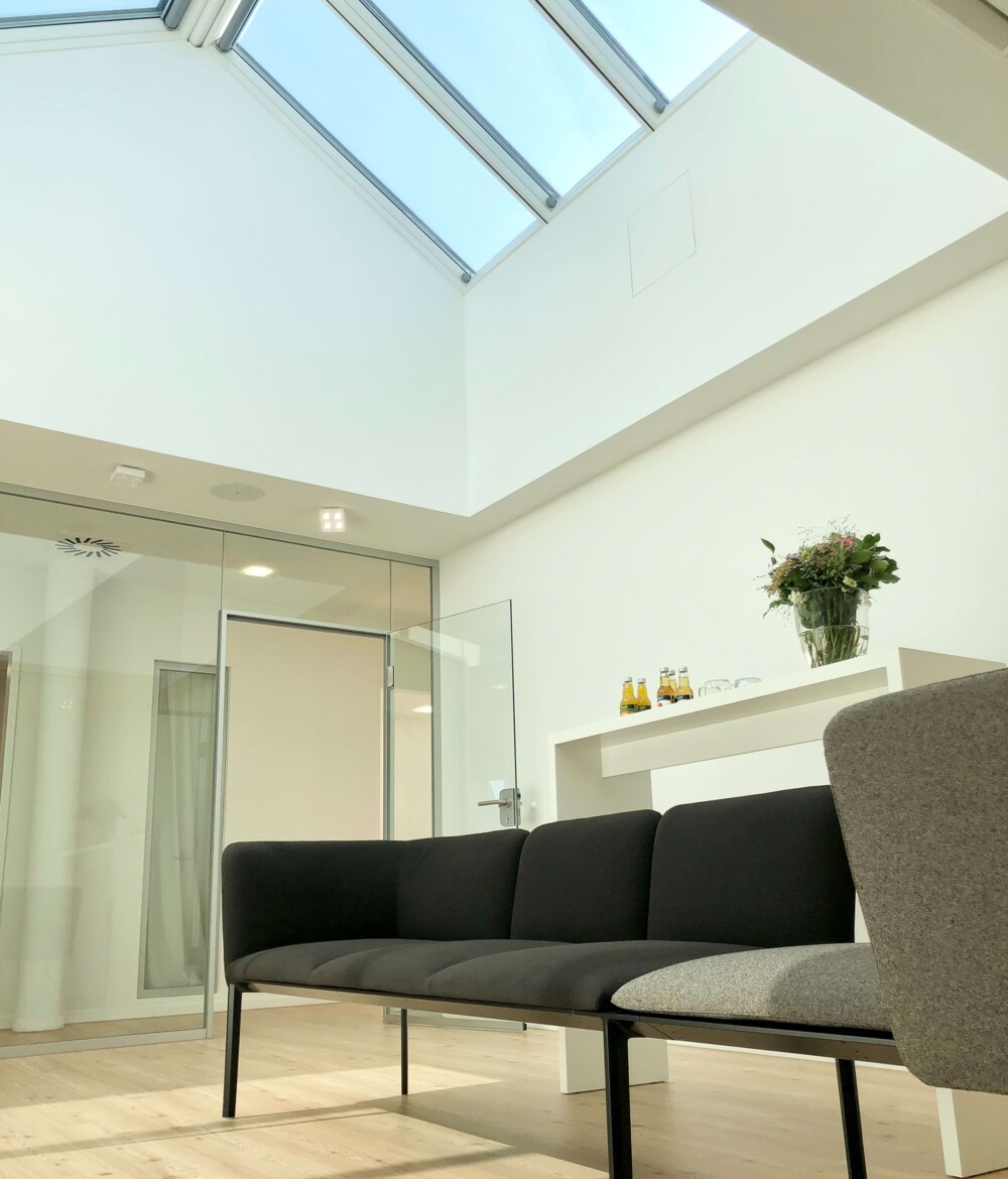 Impressionen aus dem hellen Wartezimmer mit hoher Decke.