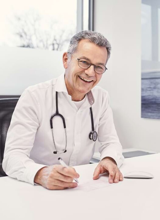 Arzt l&auml;chelt bei der Beratung