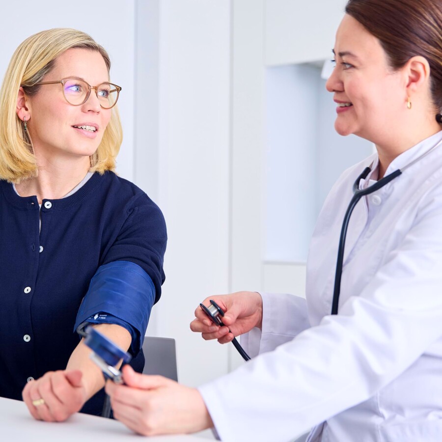 Eine &Auml;rztin misst den Blutdruck einer Patientin.