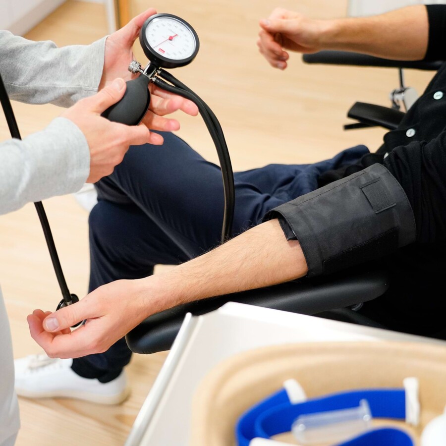 Detailaufnahme einer Armbeuge w&auml;hrend der Blutdruckmessung durch medizinisches Fachpersonal f&uuml;r die Tauglichkeitsuntersuchung des F&uuml;hrerscheins.
