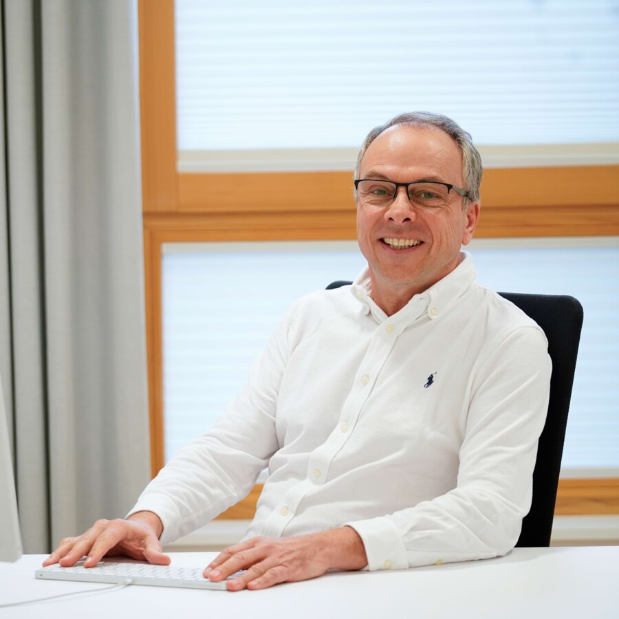 Ein Arzt lacht in die Kamera.