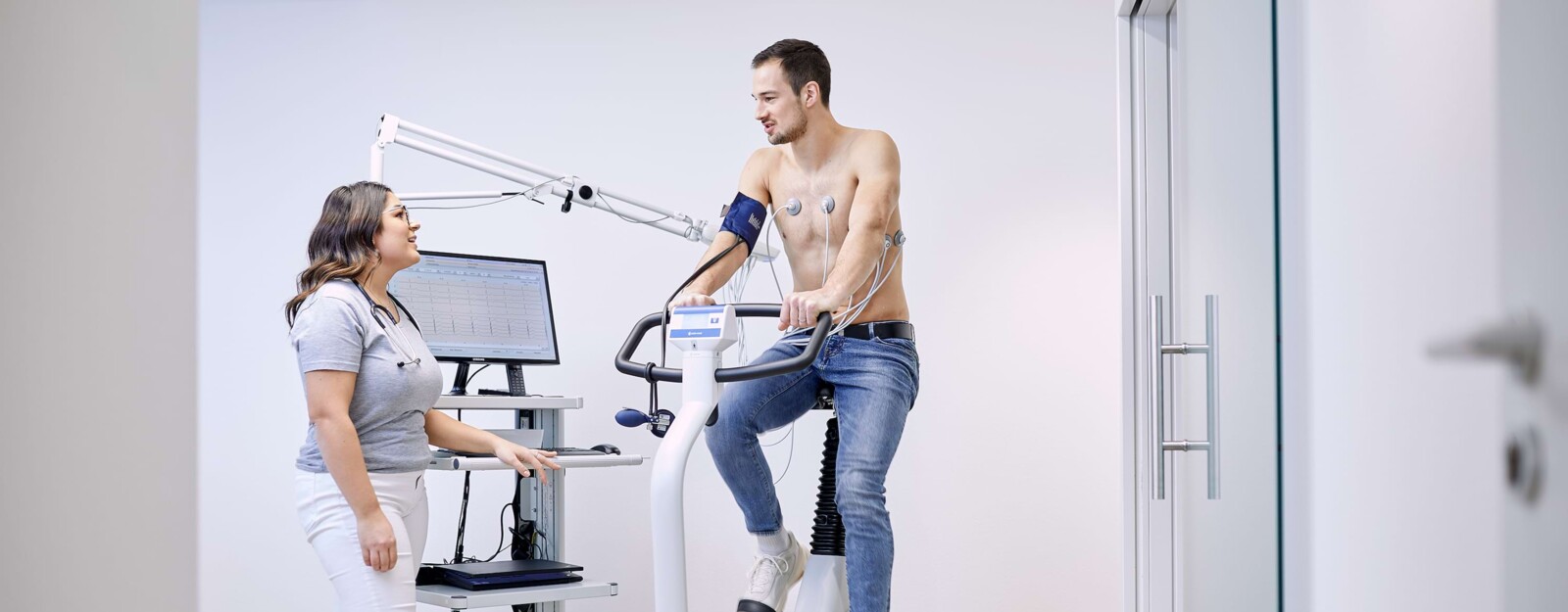 Kardiologische Messung eines Patienten auf einem Pedaltrainer.