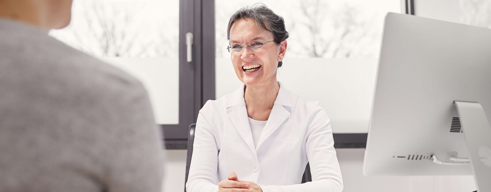 Eine &Auml;rztin ber&auml;t einen Patienten.