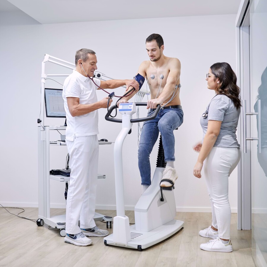 Ein Patient wird von einem Arzt und Helferin untersucht.