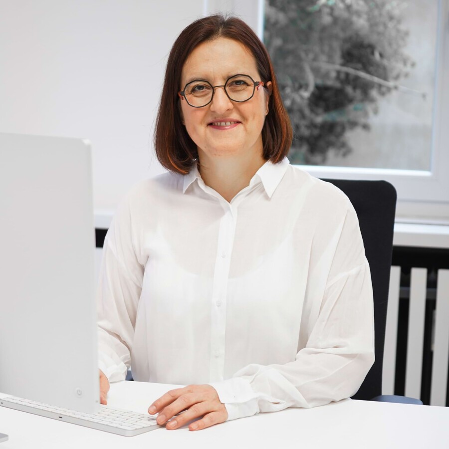 Eine &Auml;rztin l&auml;chelt in die Kamera.